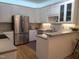 Bright kitchen with stainless steel appliances, white cabinetry, and hardwood floors at 12 Crail Ct, Durham, NC 27712