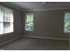 Neutral bedroom with a ceiling fan, three windows, and wall-to-wall carpeting at 12 Crail Ct, Durham, NC 27712