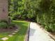 Landscaped gravel path with brick trim surrounded by lush greenery at 12 Crail Ct, Durham, NC 27712