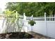 Backyard with well maintained, tall white picket fence, plants and decorative hanging flower basket at 120 Jennel Way, Durham, NC 27707