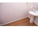 Bathroom with a pedestal sink, wood-look flooring, white trim and light pink walls at 120 Jennel Way, Durham, NC 27707