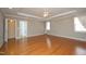 Large bedroom with three windows, ceiling fan, hardwood floors and neutral colored walls at 120 Jennel Way, Durham, NC 27707
