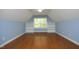 Spacious bedroom with blue walls, hardwood floors, built-in shelving and a window offering natural light at 120 Jennel Way, Durham, NC 27707