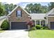 Charming home featuring stone accents, a two-car garage, well-manicured lawn, and a welcoming entrance at 120 Jennel Way, Durham, NC 27707