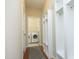 Hallway featuring access to a laundry room, a patterned rug, and built in storage with coat hooks at 120 Jennel Way, Durham, NC 27707