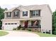 Inviting two-story home with a cozy front porch, attached garage, and well-maintained lawn at 123 Scheer Ave, Durham, NC 27703