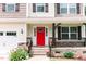 Close up of a charming front porch with stone detail, colorful landscaping and a bright red front door at 123 Scheer Ave, Durham, NC 27703