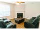 Cozy living room with a fireplace, ceiling fan, and plush leather seating at 123 Scheer Ave, Durham, NC 27703