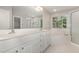 Bright bathroom featuring double sinks, white cabinets, and bathtub at 124 Cypress View Way, Apex, NC 27502