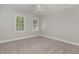 Spacious bedroom featuring two windows and neutral walls, illuminated by a ceiling fan at 124 Cypress View Way, Apex, NC 27502