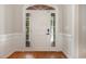 Bright foyer featuring a white front door, wood floors, and classic wainscoting at 124 Cypress View Way, Apex, NC 27502