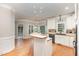 Open kitchen with white cabinets, wood countertops, an island cooktop, and stainless steel dishwasher at 124 Cypress View Way, Apex, NC 27502