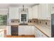 Bright kitchen with stainless steel dishwasher, wood countertops, and backsplash at 124 Cypress View Way, Apex, NC 27502
