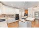 Bright kitchen featuring white cabinetry, wood countertops, modern appliances, and a breakfast bar with seating at 124 Cypress View Way, Apex, NC 27502