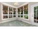 Bright sunroom with tile flooring, large windows, and backyard views at 124 Cypress View Way, Apex, NC 27502
