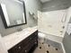This bathroom features a bath tub, sink with dark wooden cabinet, a toilet and tiled floors at 129 Friar Ln, Carrboro, NC 27510