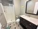 This bathroom includes a shower with curtain, a sink with a dark wooden cabinet, and tiled floors at 129 Friar Ln, Carrboro, NC 27510