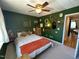 This bedroom features a large window for natural light, a ceiling fan, and artistic decorations at 129 Friar Ln, Carrboro, NC 27510