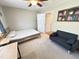 This bedroom includes a grey couch, bed with wood headboard, and light colored carpet at 129 Friar Ln, Carrboro, NC 27510