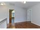 Upstairs hallway displaying hardwood floors and a view to a bedroom with an arched window at 1310 Southgate Dr, Raleigh, NC 27610