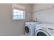 Laundry room with washer, dryer, window, and overhead storage rack at 1310 Southgate Dr, Raleigh, NC 27610