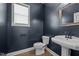 Stylish half-bathroom with dark walls, pedestal sink, and a decorative mirror at 137 Campaign Dr, Mebane, NC 27302