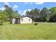 Spacious backyard with green lawn, utility shed, and a tree line in the background at 1512 Bacon St, Durham, NC 27701