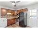 Cozy kitchen featuring wood cabinets, tile backsplash, and stainless-steel appliances at 1512 Bacon St, Durham, NC 27701