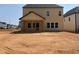 Backyard view of a tan two story house and newly seeded lot at 1613 Malcus Ct # 68, Fuquay Varina, NC 27526