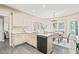 Bright kitchen features white cabinetry, sleek black appliances, and an adjacent dining area for easy meals at 1717 Ormond Rd, Hurdle Mills, NC 27541