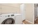Functional laundry room with washer, dryer, storage cabinet, and wire shelving at 1717 Ormond Rd, Hurdle Mills, NC 27541