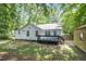 Backyard featuring a deck, shed, and lawn with surrounding trees and partial fencing at 2007 Eastwood Dr, Durham, NC 27703