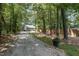 Home with a long driveway and fenced in yard, surrounded by lush trees at 2007 Eastwood Dr, Durham, NC 27703