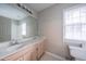 Bathroom with a double sink vanity, large mirror, window with blinds, toilet, and tile flooring at 203 Halls Mill Dr, Cary, NC 27519