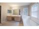 Large bathroom area with double sinks, vanity area, garden tub, and natural light from the window at 203 Halls Mill Dr, Cary, NC 27519
