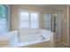 Relaxing soaking tub with jets, a shower, and a large window that fills with natural light at 203 Halls Mill Dr, Cary, NC 27519