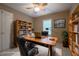 Staged home office with ceiling fan, shelving, and a large desk at 203 Halls Mill Dr, Cary, NC 27519