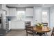 Bright kitchen featuring white cabinets, stainless steel appliances, and a round dining table at 222 Rosewood Dr, Sanford, NC 27330