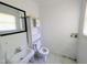 Bathroom features a classic sink, toilet, storage unit, and natural light from a window at 2309 Chautauqua Ave, Durham, NC 27707