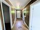 Narrow hallway with wood paneling and a damaged floor at 2309 Chautauqua Ave, Durham, NC 27707