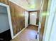 Hallway with wood paneling, white trim, and access to multiple rooms, leading to the home's interior at 2309 Chautauqua Ave, Durham, NC 27707