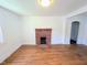 Bright living room featuring original hardwood floors and a classic brick fireplace at 2309 Chautauqua Ave, Durham, NC 27707