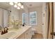 Spacious bathroom featuring dual sinks, large mirrors, neutral decor, and natural lighting at 2312 Brasswynd Ct, Fuquay Varina, NC 27526