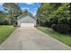 Detached garage with an expansive driveway and well maintained lawn with mature trees at 2312 Brasswynd Ct, Fuquay Varina, NC 27526