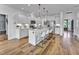 Bright kitchen features stainless appliances, white cabinets, large island with seating, and wood flooring at 2371 Old Us 421, Lillington, NC 27546