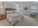 Bright main bedroom featuring a cozy bed with a tufted headboard, soft carpet, and natural light at 2371 Old Us 421, Lillington, NC 27546