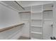 Walk-in closet with wooden rods for hanging and white shelving for storage at 2371 Old Us 421, Lillington, NC 27546