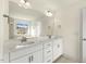 Bright bathroom featuring double sinks, white cabinets, granite countertops and a large framed mirror at 25 Long Needle Ct # 37, Youngsville, NC 27596