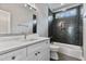 Chic bathroom boasts a white vanity, stylish mirror, and a tiled shower-bathtub combination at 2521 Newbold St, Raleigh, NC 27603