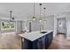 A kitchen with a blue island, stainless steel appliances, white countertops, and an open floor plan at 2521 Newbold St, Raleigh, NC 27603